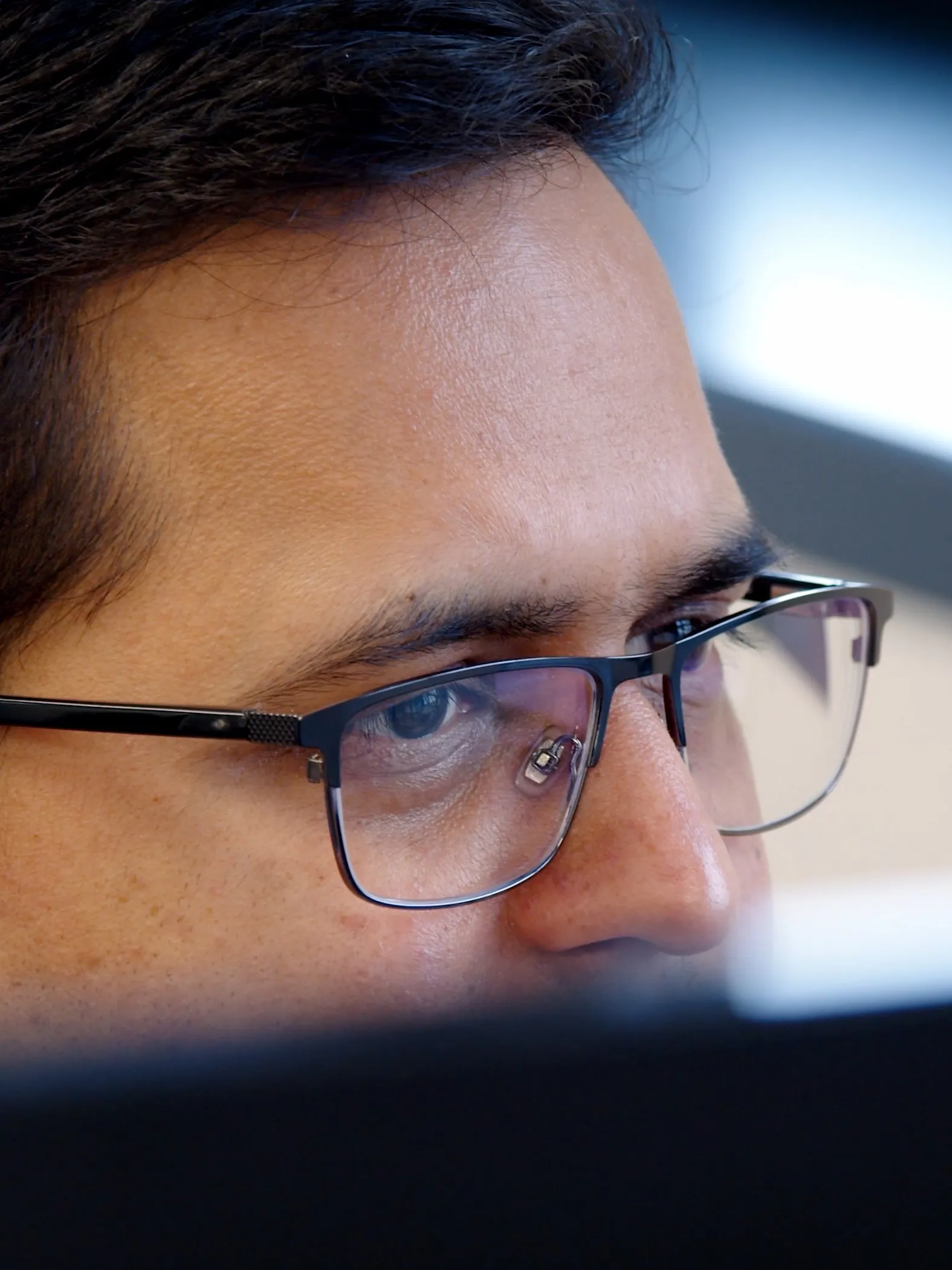 Close-up of Rahul focused on a contract review in GenieAI