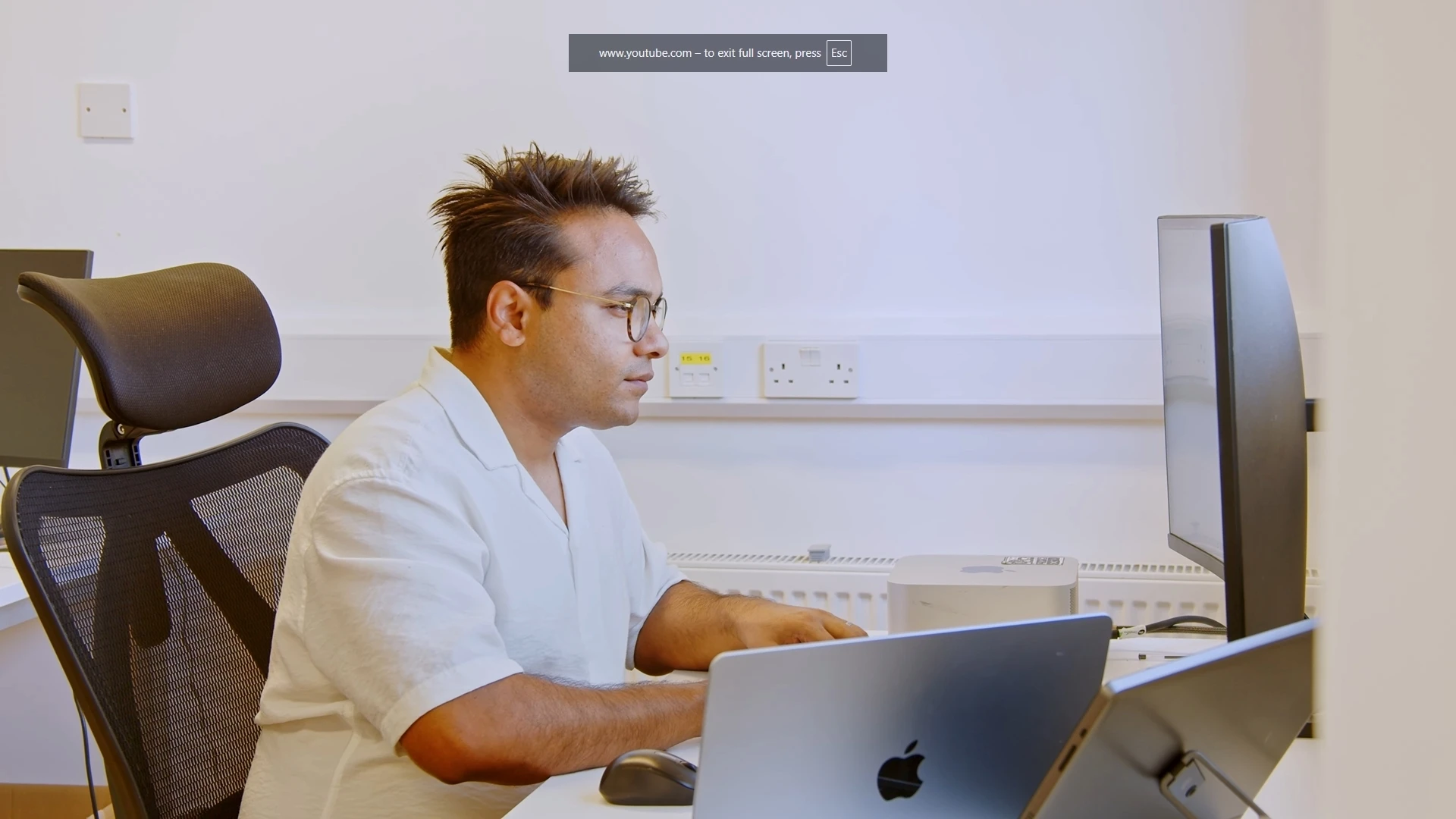 Co-founder reviewing a contract in GenieAI on a multi-monitor workstation