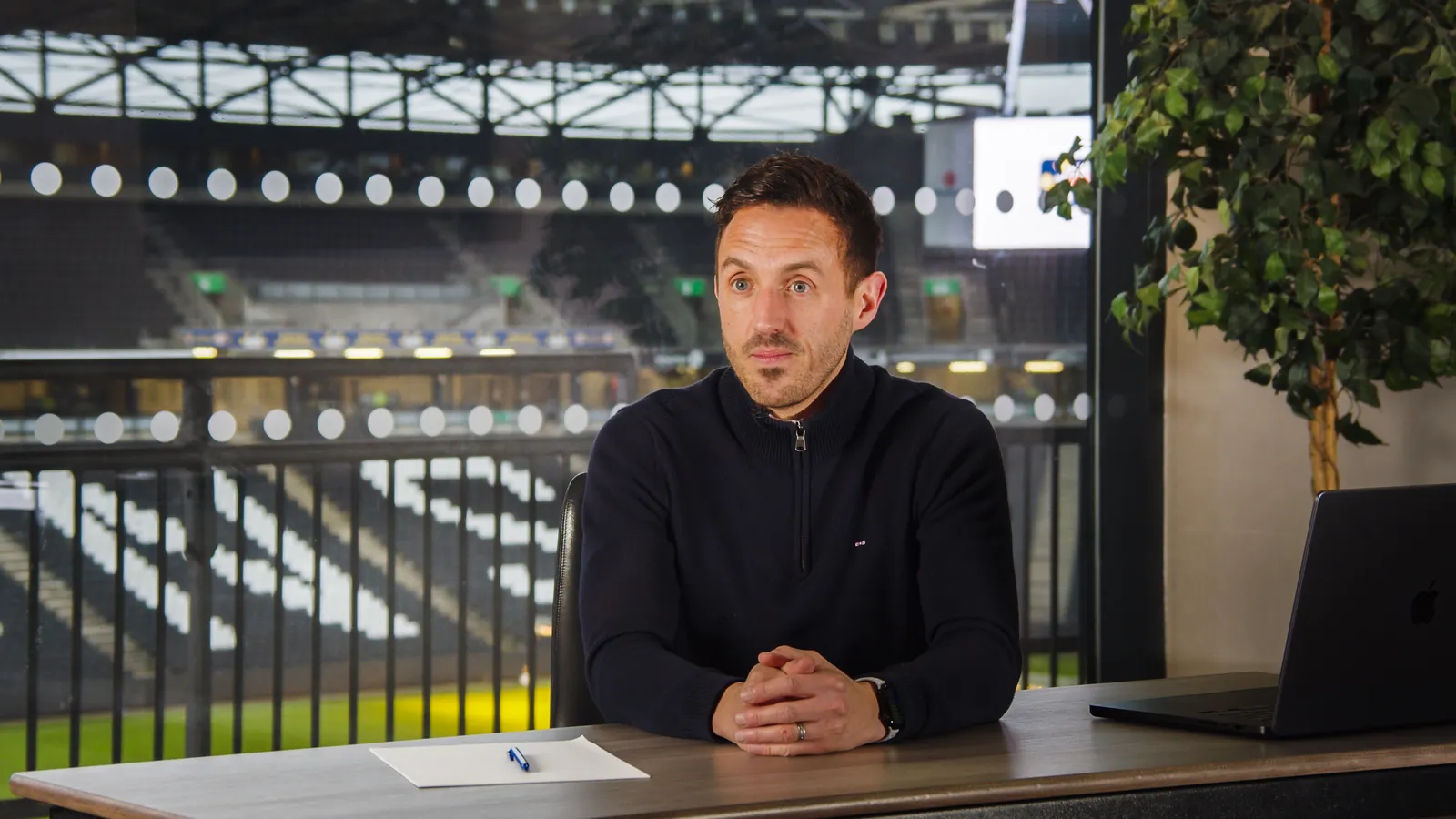 Mark Davies at the desk, Stadium MK behind him